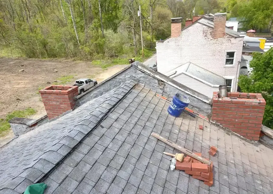 A brick chimney being rebuilt and repointed with fresh mortar