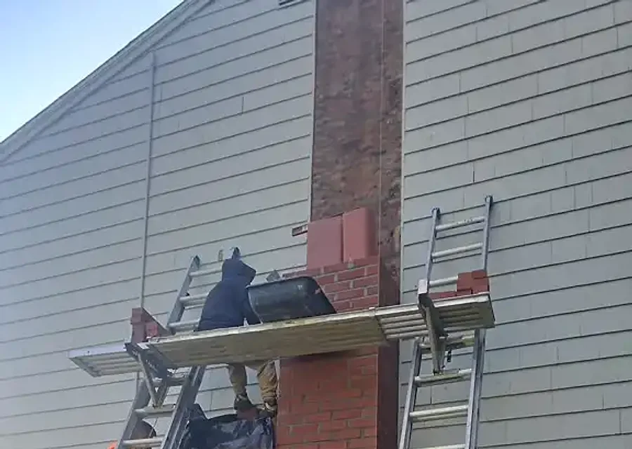 A brick chimney with new copper flashing sealing where it meets the roof